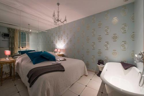 a bedroom with a bed and a tub and a sink at Le Mascaret - Restaurant Hotel Spa - Teritoria in Blainville-sur-Mer