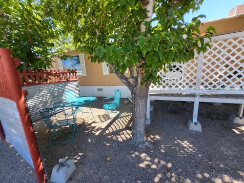 a table and chairs under a tree next to a fence at destination getaway in Truth or Consequences