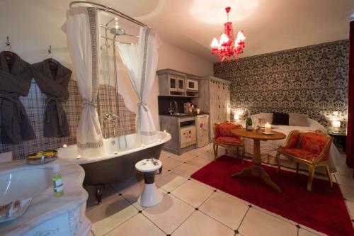 a bathroom with a tub and a sink and a table at Le Mascaret - Restaurant Hotel Spa - Teritoria in Blainville-sur-Mer