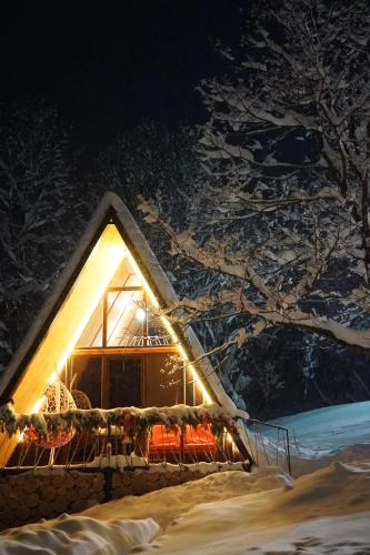 a house covered in snow at night with lights at GLAMPING WOLF MOUNt in Margahovit