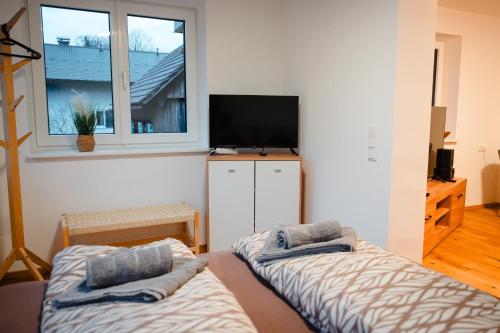 two beds in a room with a tv and a window at Sepperls Stubn Apartment - PETS no extra cost - Bad Goisern - 24-hours Self check-in in Bad Goisern