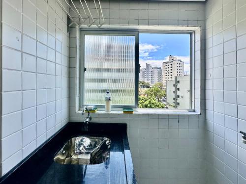 a bathroom with a sink and a window at João Machado Fortes in Florianópolis