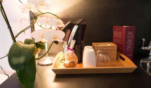 a wooden tray with a vase and flowers on a table at Le Mascaret - Restaurant Hotel Spa - Teritoria in Blainville-sur-Mer