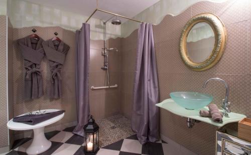 a bathroom with a sink and a shower with purple curtains at Le Mascaret - Restaurant Hotel Spa - Teritoria in Blainville-sur-Mer