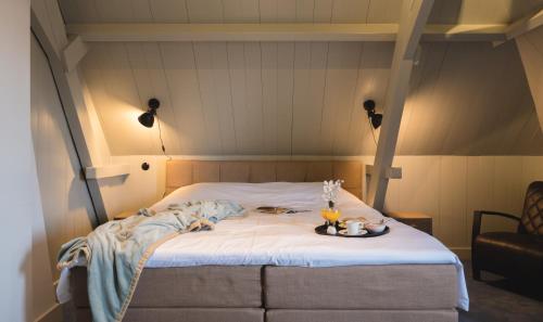 a bed with a tray of food on top of it at Herberg de Gouden Leeuw in Bronkhorst