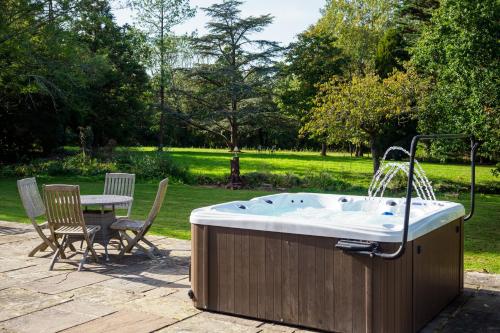 ChiddinglyにあるCountryside Retreat packed with Activities Tennis including Hot Tub, BBQ, Dartsのホットタブ(噴水、テーブル、椅子付)
