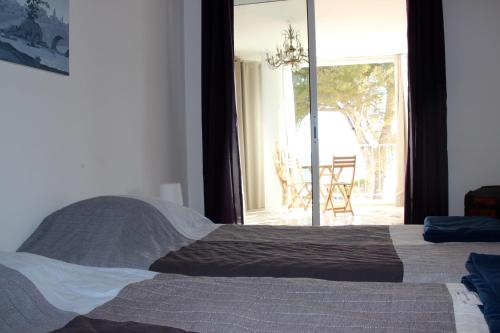 カリー・ル・ルエにあるAppartement bord de merのベッドとガラスの引き戸のある寝室