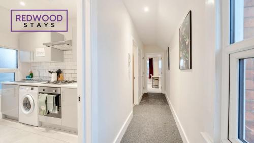 a kitchen with a washer and dryer in a house at Newly Refurbished Everest Lodge Serviced Apartments for Contractors & Families, FREE WiFi & Netflix by REDWOOD STAYS in Farnborough