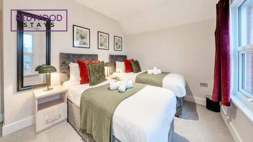 a bedroom with two beds and a sign on the wall at Newly Refurbished Everest Lodge Serviced Apartments for Contractors & Families, FREE WiFi & Netflix by REDWOOD STAYS in Farnborough