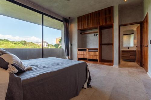 a bedroom with a large bed and a large window at La Olita in Puerto Escondido