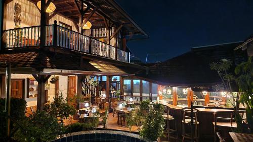 an outdoor patio with tables and chairs at night at Greenheart Boutique Hotel in Paramaribo