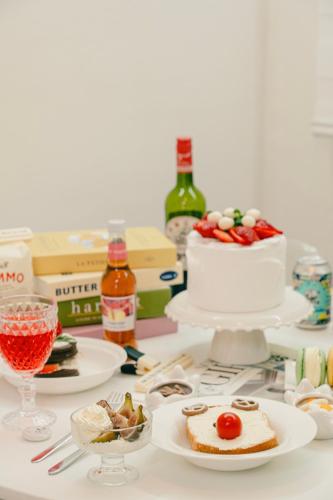 a table topped with plates of food and a cake at Cozy Gangnam Jamsil KSPO DOM in Seoul