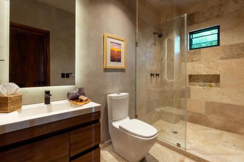 a bathroom with a toilet and a glass shower at La Olita in Puerto Escondido