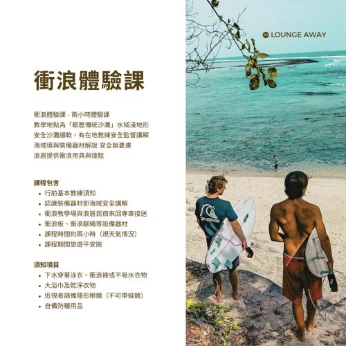 two people walking on the beach with a surfboard at Lounge away in Taitung City