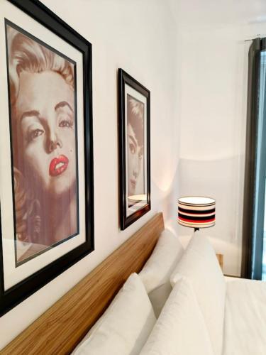 a living room with a white couch and two framed pictures at Sea Esta 2 in Il-Gżira
