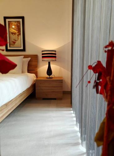 a bedroom with a bed and a lamp on a night stand at Sea Esta 2 in Il-Gżira