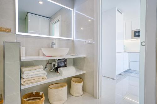 une salle de bain blanche avec un lavabo et un miroir dans l'établissement Doñana Seaside Views by Homestaygrancanaria, à Patalavaca