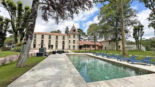 un immeuble avec une piscine devant un immeuble dans l'établissement Le manoir des perrieres, à Rochechouart