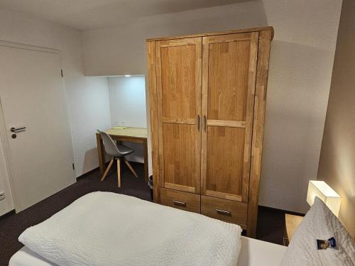 a bedroom with a bed and a wooden cabinet at Parkhotel Senftenberg in Senftenberg