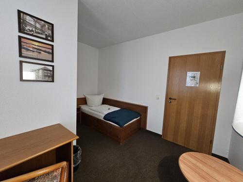 a small room with a bed and a door at Parkhotel Senftenberg in Senftenberg