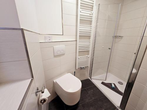 a white bathroom with a toilet and a shower at Parkhotel Senftenberg in Senftenberg