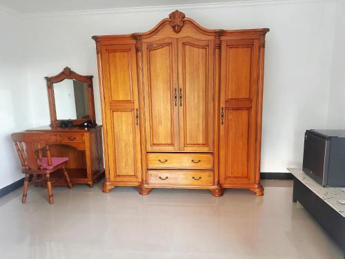 a wooden cabinet next to a dresser and a mirror at Amanda Villa - Best Value Mountain top Inn in Au Cap