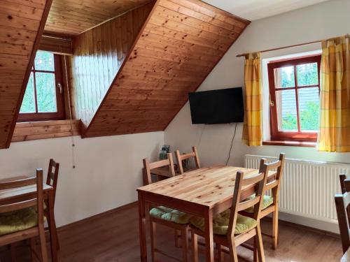 a dining room with a wooden table and chairs at Penzion Medvídek in Josefuv dul