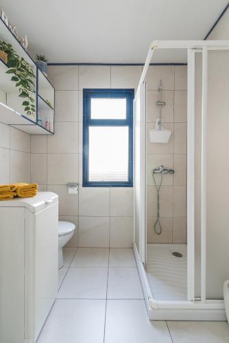 a white bathroom with a shower and a toilet at Corona Rosa Ocean View in Puerto Rico de Gran Canaria