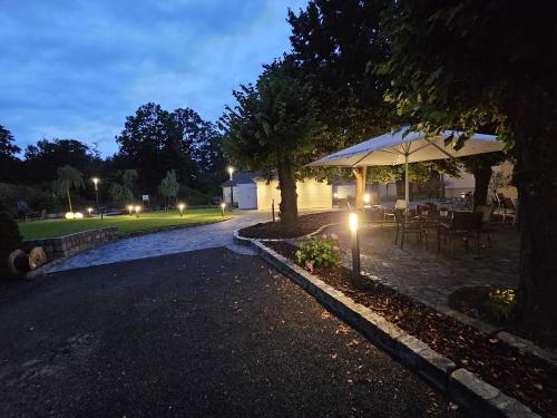 a patio with a table and an umbrella at night at Parkhotel Senftenberg in Senftenberg