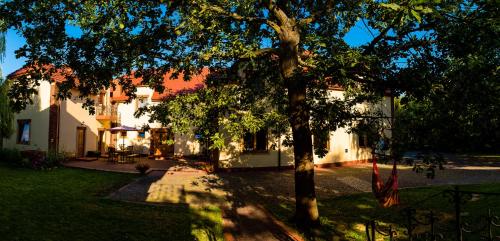 a house with a tree in front of it at Gościniec Koćmierzów in Sandomierz
