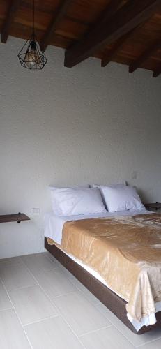 a bedroom with a bed with white sheets and pillows at Sedonascapes in Palmitas