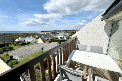 een balkon met een tafel en stoelen en uitzicht bij Superbe appartement duplex - Vue mer - Piscine in Guidel