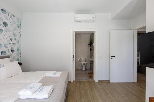 a bedroom with a bed and a bathroom with a toilet at Eveland Accessible Villas in Sfakaki