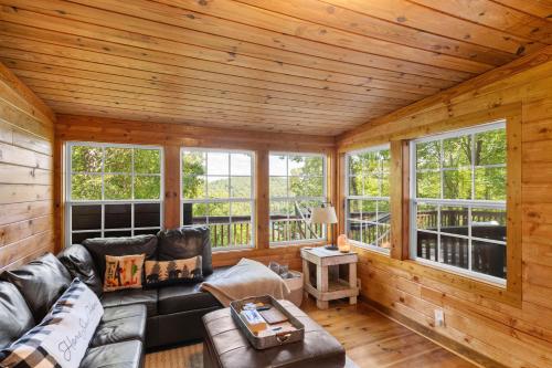 a living room with a leather couch in a log cabin at Lakeview Hideaway in Ellijay
