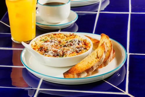 a plate of food with a bowl of soup and bread at Ace Hotel & Swim Club Athens in Athens