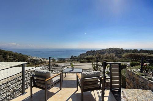 a patio with a table and chairs and the ocean at Horizon Studios - Apartments in Rodakino