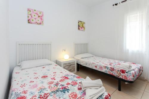 罗列特海岸Apartamento Jesma的有两张床和一盏灯的卧室