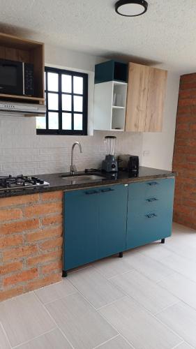 a kitchen with blue cabinets and a counter top at Sedonascapes in Palmitas