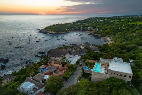 an aerial view of a village on the water with boats at La Olita in Puerto Escondido