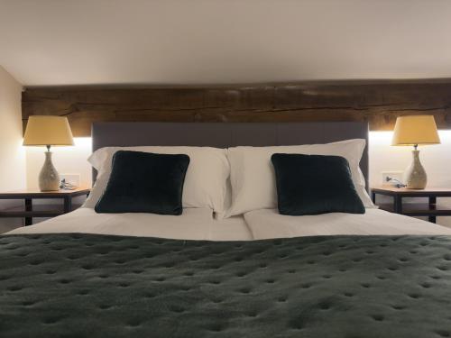 a bedroom with a large bed with two lamps at Il Cervo Chambres d'hôtes in Aosta