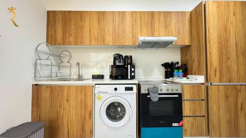 a kitchen with a washing machine and a washer at Veridian Stay 2BR Oasis - Stylish & Modern in Abu Dhabi