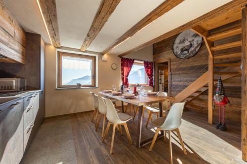 a kitchen and dining room with a table and chairs at Les rêves des Montagnards, Appartements de Charme in Torgnon