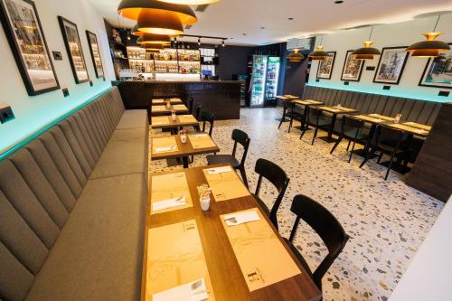 a restaurant with wooden tables and chairs and a bar at Classy apartments in city centar in Zadar