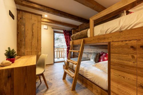 a bedroom with a bunk bed and a desk at Les rêves des Montagnards, Appartements de Charme in Torgnon