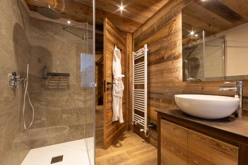 a bathroom with a sink and a glass shower at Les rêves des Montagnards, Appartements de Charme in Torgnon