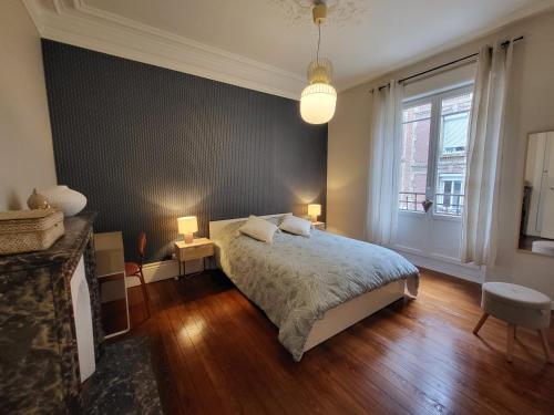 a bedroom with a bed and a large window at Le Havre Haussmannien - Rénové, Balnéo, proche Centre-ville et Gare in Le Havre