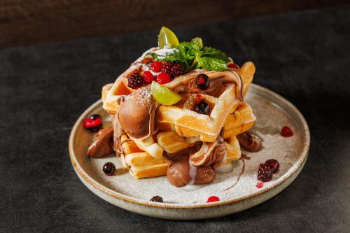 a plate of waffles with fruit on a table at Prestige design rooms in Zadar