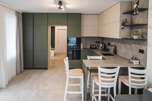 una cocina con armarios verdes y una barra con taburetes en Apartment Aria 3, en Velingrad