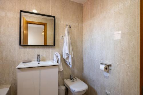 un bagno con un water, un lavandino e uno specchio di Atico Gran Esperanza a Fuengirola