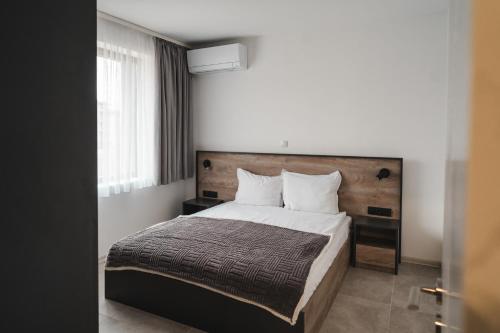 a bedroom with a large bed with a wooden headboard at Apartment Aria 3 in Velingrad